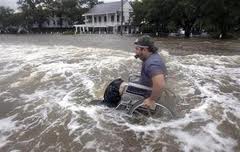 Man in a wheelchair pushing himself in two feet of flood waters